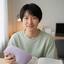 大学生のSarada 本間さんが自宅の机でアイピローを手にしている様子